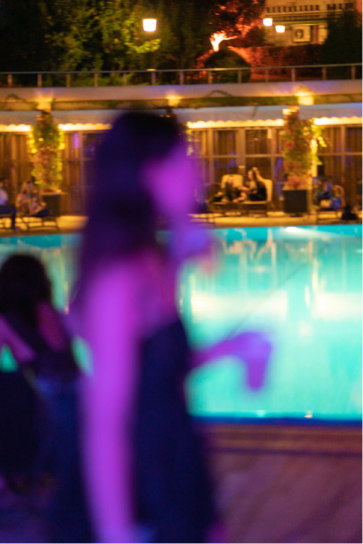 A moving figure crossing the KULÜP poolside atmosphere