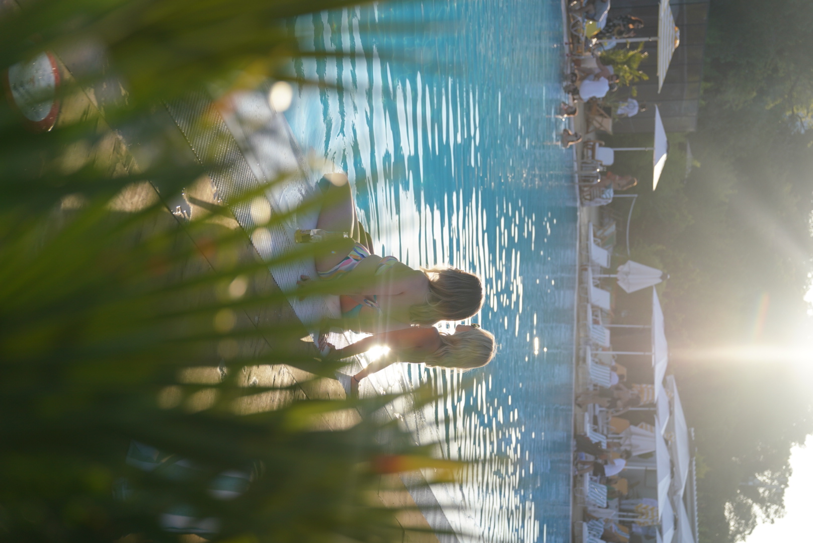 SUNDAZE guests sitting at the pool edge in Bebeköy at sunset